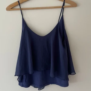 Mörkblå linnetopp från Gina Tricot - Säljer en mörkblå linnetopp från Gina Tricot med tunna axelband som är lite urringad i ryggen