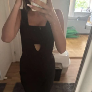 Svart kort klänning från Bik Bok - En svart, tight och ärmlös klänning från Bik Bok i storlek S. Klänningen har en djup v-ringning framtill och är figurnära med kort längd. Perfekt för dig som gillar en stilren och enkel look. Sista bilden finns ett icke synbart fel med tråden, går att klippa av. 