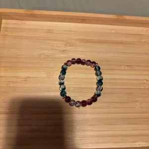 Färgglatt pärlarmband i blått och rosa - Ett stretchigt armband med runda pärlor i blått, rosa och transparent. Pärlorna har en glittrig finish som ger extra bling. Perfekt accessoar för att liva upp din outfit.