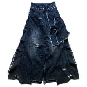 Ranger Cartel X detachable-skirt denim  - X detachable-skirt denim från Ranger Cartel i storlek XS. Midjemått 72cm, innerbenslängd 84cm. ”the ranger ‘X detachable-skirt denim’ is an innovative 3 piece garment that can be styled and worn in many different ways. the large maxi skirt is completely detachable via a zipper that wraps around the waist, revealing a pair of black flared denim underneath, with an elevated flared fit and gorgeous dye. a scar stitch covers almost every seam across the skirt, each stitch carefully hand placed.”