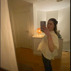Ljusgul blus med puffärmar från Gina Tricot - Supersöt ljusgul blus från Gina Tricot med puffiga korta ärmar och volang nedtill. Blusen har en lätt strukturerad yta och rund halsringning. Perfekt för dig som gillar en romantisk och trendig stil.