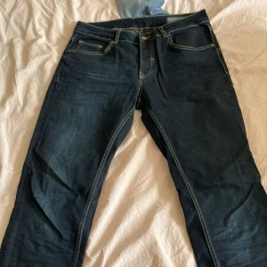 Mörkblå jeans från Sorbino - Snygga mörkblå jeans från Sorbino med kontrasterande gula sömmar. Klassisk femficksmodell i rak passform och robust denimkänsla. Perfekta för dig som gillar stilrena och tidlösa jeans med en modern touch.