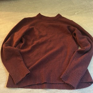 Vinröd stickad tröja från Amisu - Mysig vinröd stickad tröja från Amisu med rund halsringning och breda ribbade muddar vid ärmslut och nederkant. Perfekt för lager-på-lager och chill höst- eller vinterstil. Enkel att matcha med jeans eller kjol.