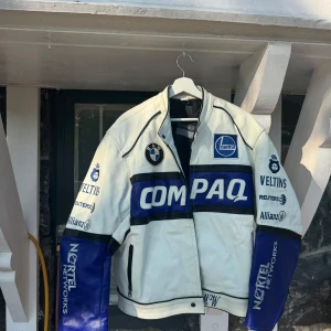 BMW Compaq skinnjacka XXL - Vintage racing jacks! Riktigt fet BMW Compaq skinnjacka i vitt och blått med broderade loggor och racing-inspirerade detaljer. Jackan har dragkedja, svarta detaljer och quiltat foder. Perfekt för dig som gillar motorsport och vill sticka ut med en unik look.