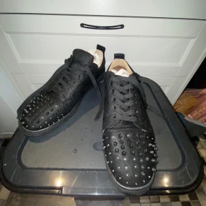Svarta Christian Louboutin sneakers med nitar - Äkta. Tvätta dom så mycket jag kunde. Några spikar som är borta.                        Sprillans nya är runt 8000 spänn.       Sulorna är förstörda men går att använda