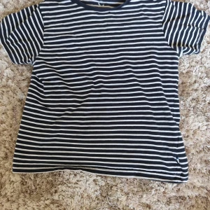 Randig t-shirt i ekologisk bomull - Svart och vit randig t-shirt från C i ekologisk bomull. Klassisk modell med rund hals och korta ärmar. Perfekt för dig som gillar enkel och stilren look med en chill vibe.