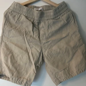 Beige shorts från Samsøe Samsøe - Säljer ett par bekväma beige shorts från Samsøe Samsøe. De har en elastisk midja och är tillverkade i ett mjukt material. Perfekta för en avslappnad stil. 43 % linne. Pris kan diskuteras!