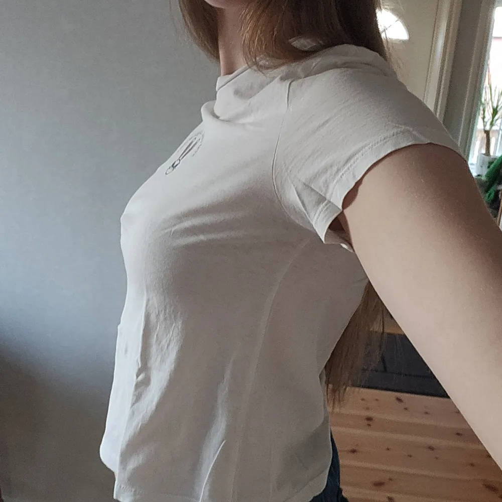 Säljer en vit t-shirt med ett tryck av en kanin och texten 'Stay Cool, Honey Bunny'. T-shirten är lite croppad och har och korta ärmar. Perfekt för en avslappnad stil.. T-paidat.