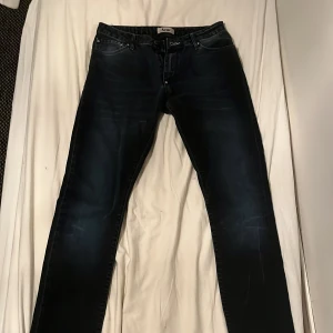 Svarta/mörk blå jeans från Acne - Snygga svarta jeans från Acne i storlek 30/34. De har en klassisk femficksdesign och är tillverkade i 100% bomul. Säljer nu för de är lite små på mig 