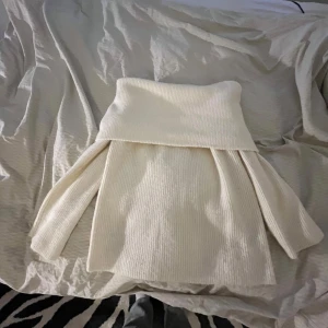 Vit offshoulder stickad tröja - Säljer en mysig vit stickad tröja med offshoulder-design. Tröjan har långa ärmar och en ribbad struktur som ger en stilren look. Perfekt för kyliga dagar när du vill vara både bekväm och trendig. Bara andvänt 1 gång och är i väldigt bra skick. 
