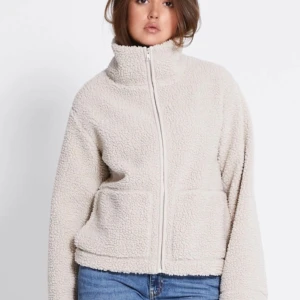 Beige teddyjacka med dragkedja - Mysig beige teddyjacka med dragkedja och hög krage. Helt ny från Lager 157, med prislappen kvar. Slutsåld 