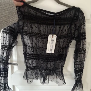 Svart Spets topp - Glittrig spets topp med prislappen kvar! Det är Xs men strechig så skulle säga att den är xs-m , oanvänd med prislapp kvar!