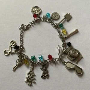 stranger things armband med olika berlocker - Stranger Things armband med flera charmiga berlocker med saker från serien! Aldrig använt i flera år, vill bara bli av med den 😭Pris kan diskuteras
