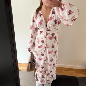 Vit blommig klänning Gina Tricot - Säljer denna efterfrågade klänning ifrån ginatricot. Jag bär vanligtvis storleken 36 och är 165 cm lång. Denna klänningen är i storlek 42 men upplever den väldigt mindre är vad som är skrivet. Alla bilder är mina och denna passar mig bra. Den skulle också passa någon med storlek 38