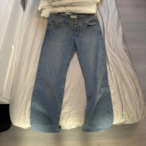 Blå jeansbyxor  - Säljer ett par klassiska blå jeansbyxor  med en straight passform. Byxorna har en knappgylf och fem fickor. Perfekta för en avslappnad stil.