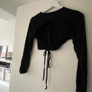 Svart långärmad öppenrygg  - Svart topp med långa ärmar och öppen rygg med knytband baktill 