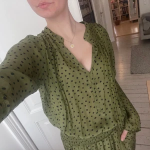 Grön prickig klänning från Rabens Saloner - Oanvänd grön klänning med prickigt mönster från Rabens Saloner. Klänningen är i storlek M och har fickor. Den är lätt och luftig perfekt för varmare dagar💚