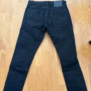 Svarta Levis 512 jeans - Snygga svarta Levis 512 jeans med en klassisk design. De har en normal passform och är tillverkade i ett slitstarkt material. Perfekta för en stilren look. 30/32 i storlek, pm för mer bilder eller funderingar.