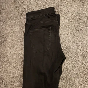 Svarta jeansbyxor - Svarta jeans från Jack & Jones. Skick 8/10, de är använda men inget som påverkar. Modell Clark. Storlek 34L 31W, hör av er vid funderingar!