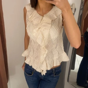 Volang blus vit/cremefärgad  - Vit/cremefärgad volang blus från Gina Tricot! I storlek 170 och passar mig som brukar ha S men skulle även passa en XS. Bara använd ett par fåtal gånger och säljer då den ej kommer till användning! Pris kan diskuteras