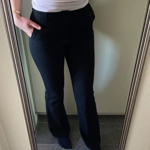 Svarta kostymbyxor från Lindex - Snygga svarta kostymbyxor från Lindex med hög midja och bootcut. De är i storlek 36 och är i fint skick. Jag är 180cm för referens.🩷 Säljs för 300kr men priset kan diskuteras.
