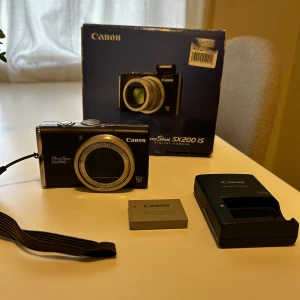 Canon Powershot SX200 IS  - Kompaktkamera från Canon. Original box, laddare,SD kort och batteri följer med. För mer frågor skriv till mig :)