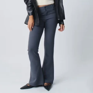 Grå bootcut byxor - Snygga grå bootcut byxor med låg/medel midja och knappar fram. Byxorna har en stilren design med fickor bak och är perfekta för en trendig look. Aldrig använda och skylten hänger kvar. Inköpta för 500kr