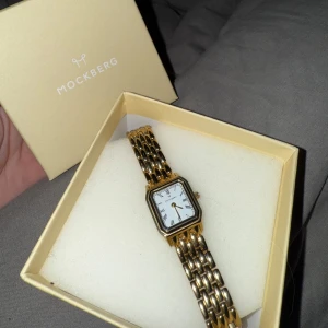 Klocka från Mockberg - Jag säljer min "Classic Watch 25mm" från Mockberg då den tyvärr inte kommer till någon användning. Klockan är otroligt fin till vardags och jag hoppas på att den kanske kan komma till användning av någon annan så småning om!💖 Klockan är i ny skick, helt utan repor eller annat som skulle tyda på att den blivit använd tidigare. Klockan skickas i sin originalbox☺️🌸 Pris kan diskuteras vid snabb affär! Hör av er vid fler frågor🩷