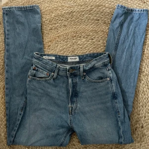 Blå jeans från Jack & Jones - Säljer ett par klassiska blå jeans från Jack & Jones. De har en relaxed fit och är tillverkade i slitstarkt denim. Perfekta för en avslappnad stil. Jeansens design inkluderar fem fickor och en knappgylf. Fint skick. Modellen ”Chris/Relaxed”. Köpt för 600kr. W27/32