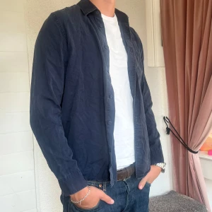 Mörkblå skjorta från Samsøe - Snygg mörkblå skjorta från Samsøe Samsøe med knappar framtill. Är i storlek L men sitter som en M.