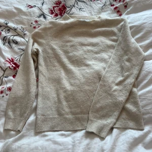 Beige stickad tröja - Säljer en mysig beige stickad tröja med långa ärmar och ribbstickade muddar. Perfekt för kyligare dagar. Passar bra till både jeans och kjol.