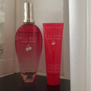 Escada Cherry in Japan parfymset - Säljer ett Escada Cherry in Japan parfymset med stor parfym och matchande body cream. Doften har körsbärstoner och är väldigt söt. Krämen är oanvänd men parfymen är lite använd 