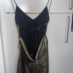 Klänning med öppen rygg - Guldig klänning från zara med öppen rygg och knytning - miniklänning passar storlek S-M (ej liten i storlek) 