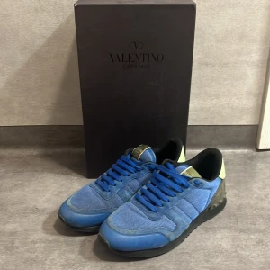 Valentino Garavani blå sneakers - Valentino rockrunner st 39 men är lite stora så passar 40 säljs på grund av ska köpa nya till vintern bra skick inte andvänd på bra tag. Om ni har frågor är de bara att skriva!
