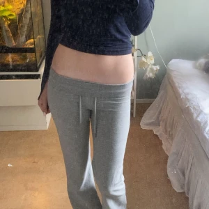 Grå mjukisbyxor med snörning - Säljer ett par grå mjukisbyxor med dragsko i midjan. Byxorna har en rak passform och är tillverkade i mjukt bomullsmaterial. Perfekta för chill dagar eller när du vill vara extra bekväm. Snygg och enkel stil som funkar till det mesta.