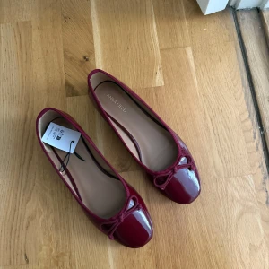 Vinröda ballerinaskor  - Snygga vinröda ballerinaskor från Anna Field med lackad finish och dekorativ rosett framtill. Skorna har rund tå och platt sula. Helt oanvända, säljs pga för små 🫶🏼