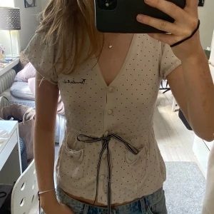 Prickig beige blus med knyt - Älskar 