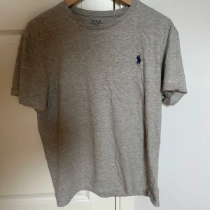 Grå t-shirt Polo Ralph Lauren - Snygg grå t-shirt från Polo Ralph Lauren med klassisk rund hals och korta ärmar. Storlek L