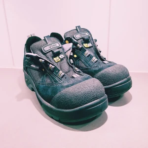 Svarta sneakers från Arbesko strl 37 - Svarta sneakers från Arbesko med robust design, förstärkt tå och detaljer i mocka och textil. Skorna har snörning med gula och grå detaljer samt stabil sula. Perfekta för dig som vill ha både stil och funktion i vardagen.  Helt & fint skick dock behövs nya skosnören