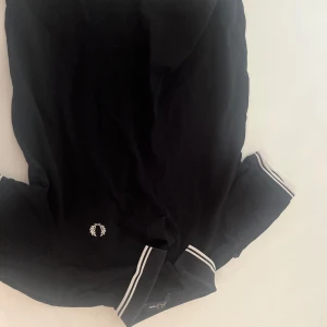 Svart pikétröja från Fred Perry - Klassisk svart pikétröja från Fred Perry  det står L men är mkt mer som S- M.