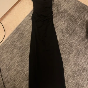 Svart långklänning - Supersnygg svart långklänning från pull & bear. Klänningen är axelbandslös