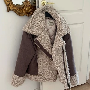 Beige teddyjacka från Odd Molly - Nypris 2225kr - Säljer en supermysig teddyjacka från Odd Molly i beige och brunt. Jackan har stora kragar, dragkedja och är fodrad. Den är tillverkad i ullblandning och har en cool, oversized look med fluffiga detaljer på krage, ärmslut och nederkant.