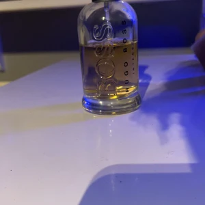 Hugo Boss Bottled Intense EdT 100ml - Säljer en klassisk Hugo Boss Bottled Intense Eau de Toilette i 100ml flaska. Parfymen kommer i en genomskinlig glasflaska med tydlig BOSS-logga och guldfärgad vätska. Perfekt för dig som gillar maskulina och fräscha dofter.