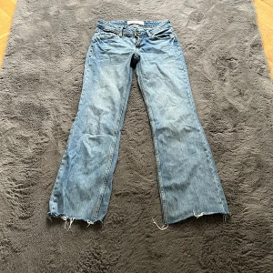 Ljusblå jeans från Bershka - Säljer ett par ljusblå jeans från Bershka i lite baggy-modell. Jeansen har råa, fransiga benslut och klassiska bakfickor med dekorativ söm. Tillverkade i bomull med en avslappnad, lite loose passform. Perfekta för en chill och trendig look.