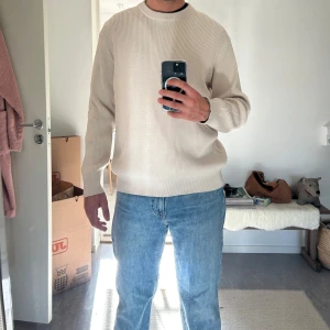 Beige ribbstickad tröja i bomull HM - Snygg beige ribbstickad tröja med rund hals och lång ärm. Tröjan har en clean och stilren look, perfekt till jeans eller chinos. Tillverkad i mjuk bomull som känns skön mot huden och passar bra för lager-på-lager under höst och vår.