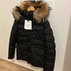 Moncler vinterjacka  - Säljer en varm pälsjacka från Moncler till ett superbra pris! Black label! Den är ej använd så skicket är som nytt! Storlek 2/M. Priset kan sänkas vid snabb affär! Skriv för mer info och intresse! 