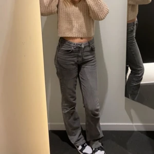 Grå bootcut jeans - Säljer ett par gråa jeans med bootcut passform. Jeansen har klassisk femficksdesign, normalhög midja och är tillverkade i ett mjukt bomullsmaterial. Perfekta för dig som gillar en avslappnad men ändå trendig look.