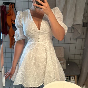 Adoore sicily dress - Den perfekta sommarklänningen från Adoore!!🤍Klänningen har knappar framtill och markerad midja som ger en snygg siluett. Perfekt för sommarens alla tillfällen. Den är endast använd 1 gång & tvättad samt steamad efter det. Den är i nyskick och har inga fläckar eller skavanker. Superfint material i 100% bomull. Nypris: 1495kr