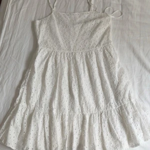 Vit sommarklänning från XSIDE - Superfin vit klänning från XSIDE med broderade hål och tunna axelband. Perfekt till sommaren. Vid frågor är det bara att ställa.