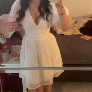 Vit omlottklänning från Gina Tricot - Supersöt vit kortklänning från Gina Tricot med omlott och v-ringning. Den har bara används 1 gång. Vid bröstet är det en liten svart tråd inuti kläningen som knappt syns. Det står även att den är i storlek 38 men på prislappen stod det 36 och passformen är även som en storlek 36! Ord pris 699. 